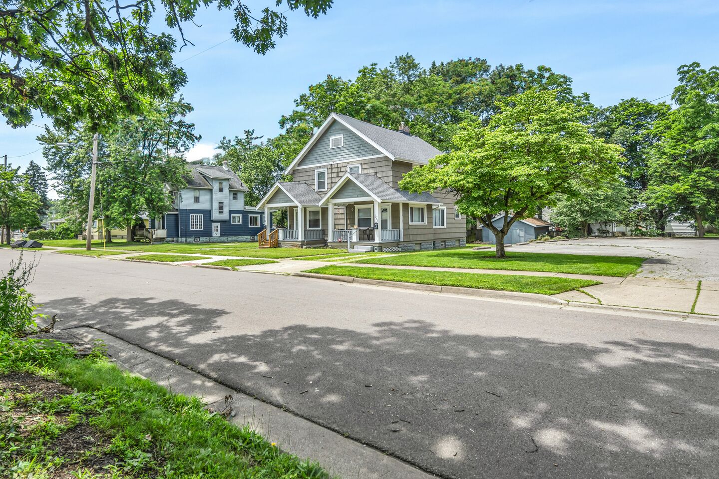 Residential street lined with trees and two-story houses