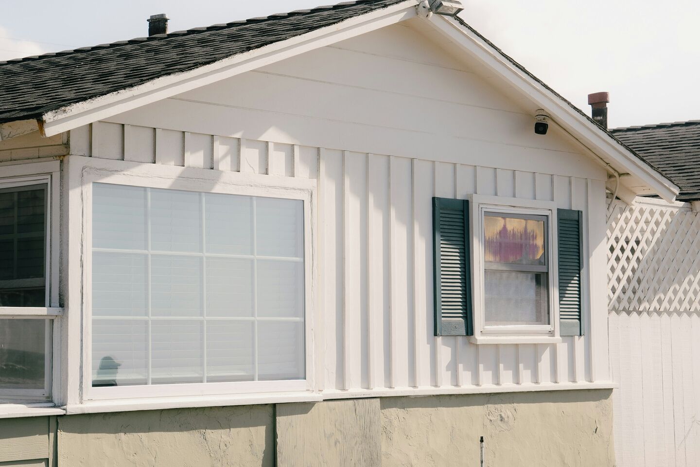 White single-story house with board and batten siding