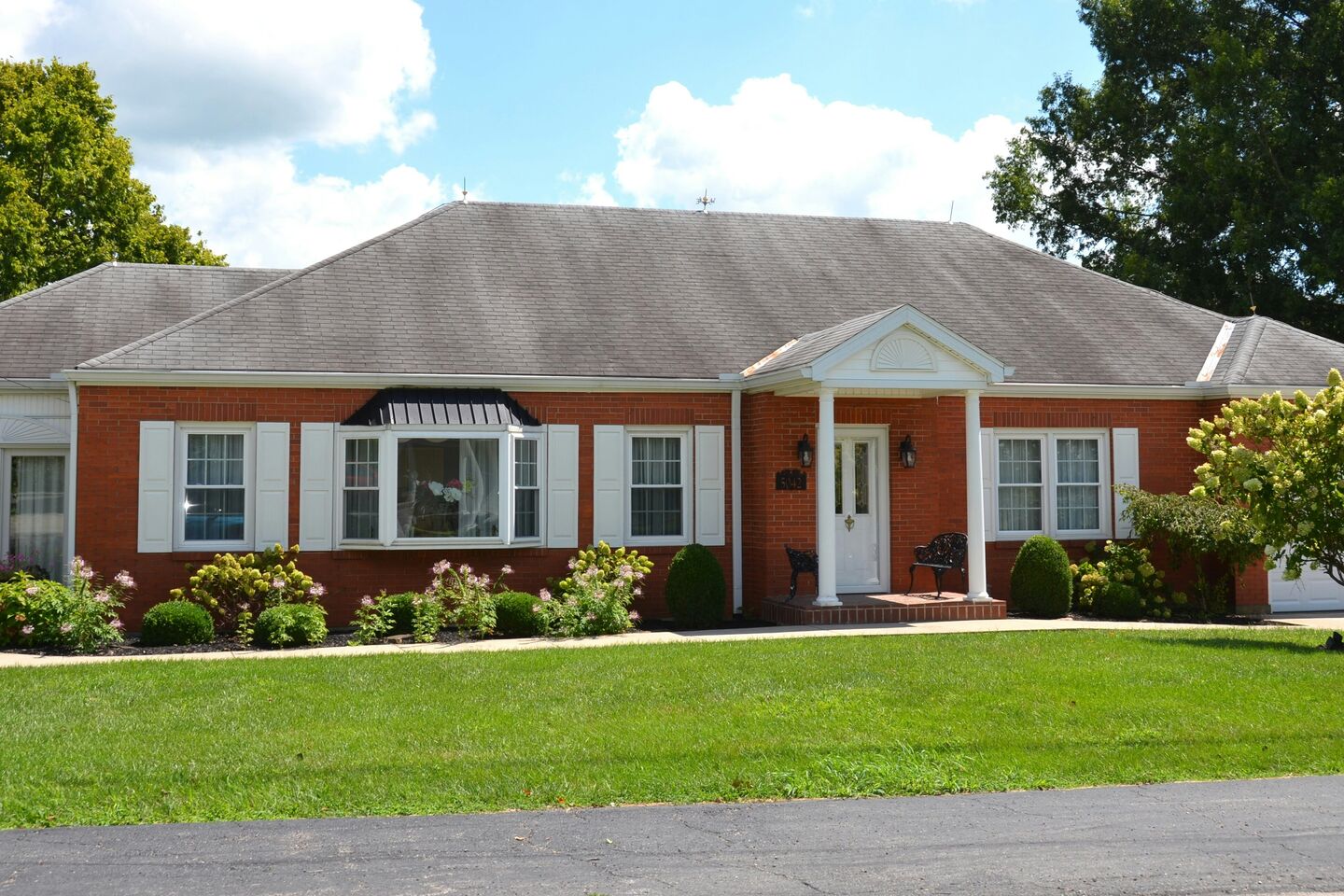 Single-story brick ranch house with a wide front lawn