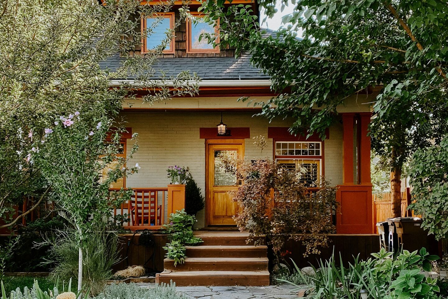Craftsman house with an orange front door and porch steps